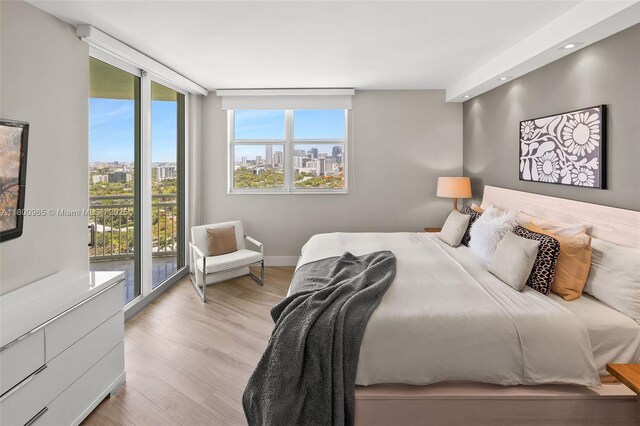 2475 Brickell Ave Unit 2002, Miami, FL 33129 - bedroom featuring access to exterior, wood finished floors, baseboards, a city view, and recessed lighting