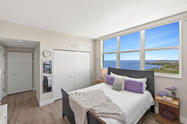 2475 Brickell Ave Unit 2002, Miami, FL 33129 - bedroom with a water view, light wood-type flooring, a closet, and baseboards
