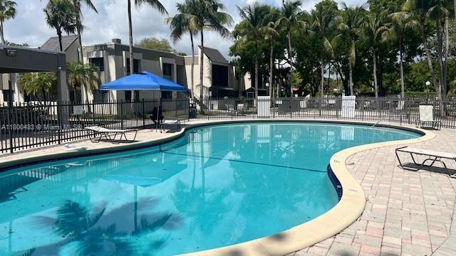 community pool featuring fence and a patio