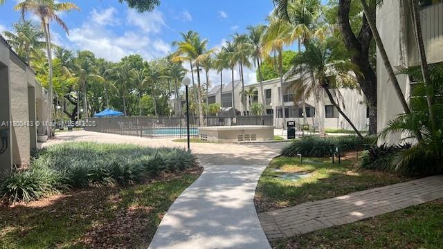 view of property's community with a swimming pool, fence, and a residential view