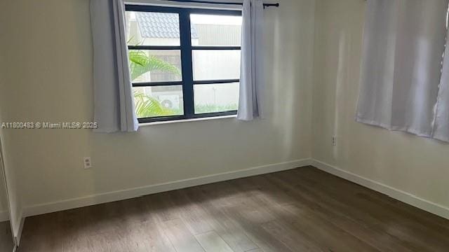 unfurnished room with baseboards and wood finished floors
