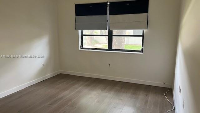 empty room featuring wood finished floors and baseboards
