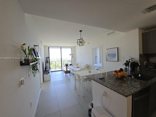 5350 NW 84th Ave Unit 1207, Doral, FL 33166 - kitchen featuring a sink, dark stone counters, light tile patterned flooring, dishwasher, and pendant lighting