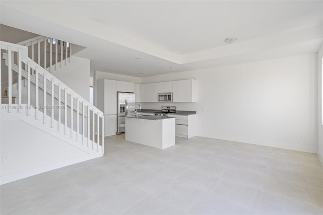18953 SW 344th Ter, Homestead, FL 33034 - kitchen with stainless steel appliances, a sink, dark countertops, an island with sink, and white cabinetry