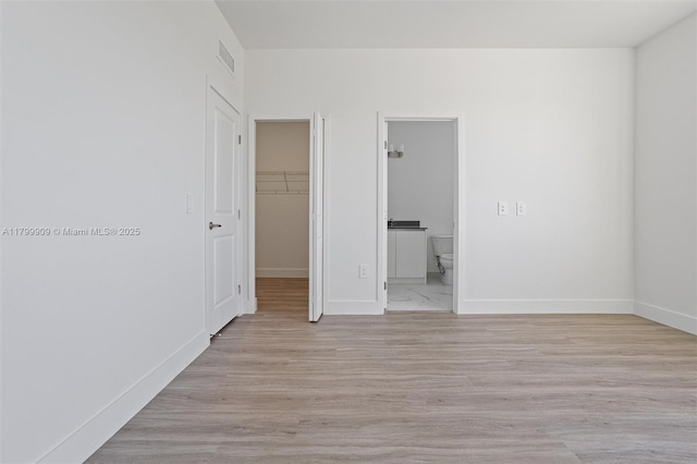 18953 SW 344th Ter, Homestead, FL 33034 - unfurnished bedroom with a walk in closet, a closet, baseboards, and ensuite bath