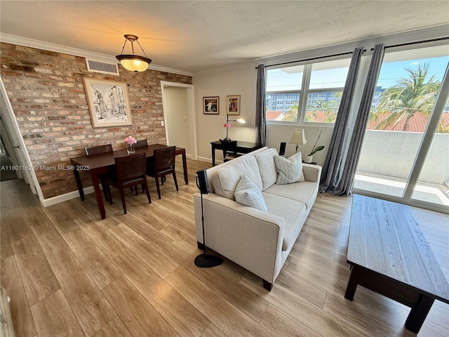 16518 NE 26th Ave Unit 405, North Miami Beach, FL 33160 - living area with ornamental molding, light wood finished floors, a textured ceiling, and baseboards