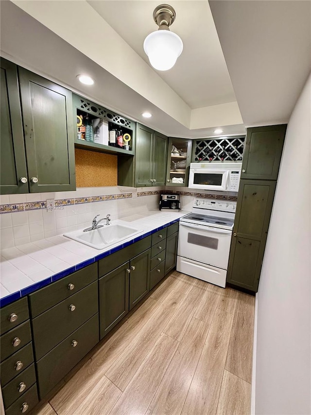 16518 NE 26th Ave Unit 405, North Miami Beach, FL 33160 - kitchen with white appliances, open shelves, a sink, green cabinetry, and light wood-style floors