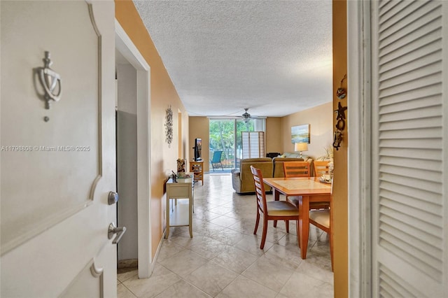 dining room with a ceiling fan, a textured ceiling, light tile patterned flooring, and floor to ceiling windows