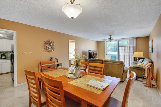 dining room featuring a ceiling fan, a textured ceiling, light tile patterned floors, and baseboards