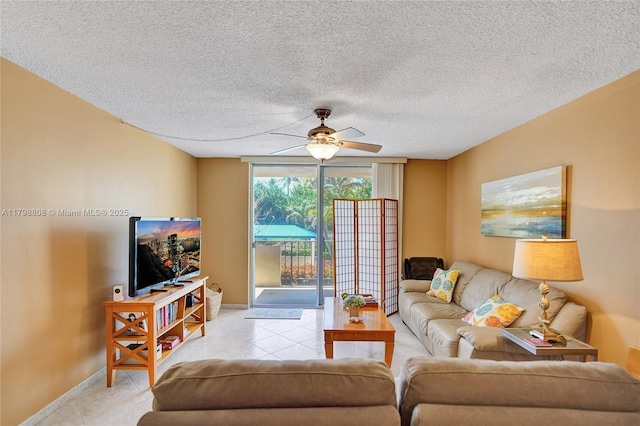 living area with ceiling fan, baseboards, a textured ceiling, and light tile patterned floors