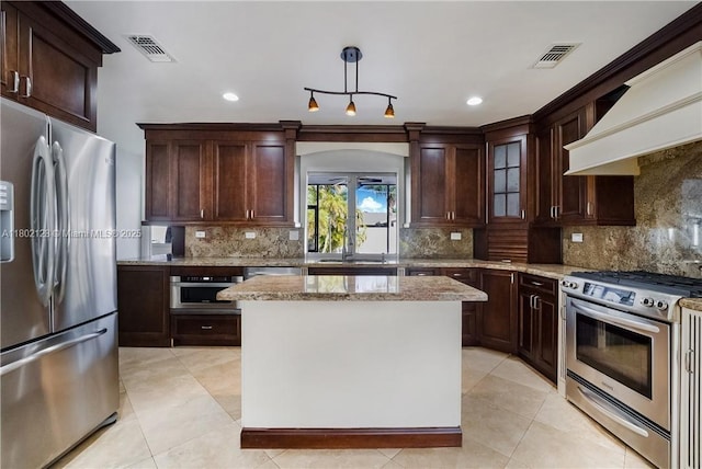 1911 NE 206th Ter, Miami, FL 33179 - kitchen featuring appliances with stainless steel finishes, premium range hood, light stone countertops, dark brown cabinets, and recessed lighting