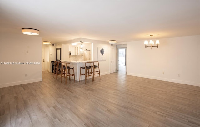 6061 Collins Ave Unit 7D, Miami Beach, FL 33140 - living room featuring a chandelier, baseboards, and light wood-style floors