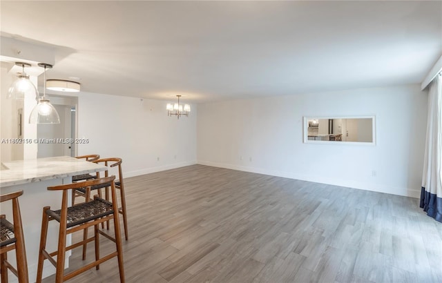 6061 Collins Ave Unit 7D, Miami Beach, FL 33140 - unfurnished dining area with wood finished floors, a chandelier, and baseboards
