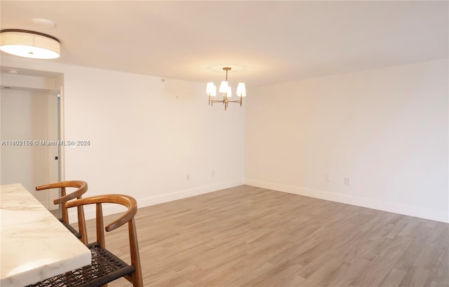 6061 Collins Ave Unit 7D, Miami Beach, FL 33140 - dining area featuring a chandelier, light wood-style flooring, and baseboards