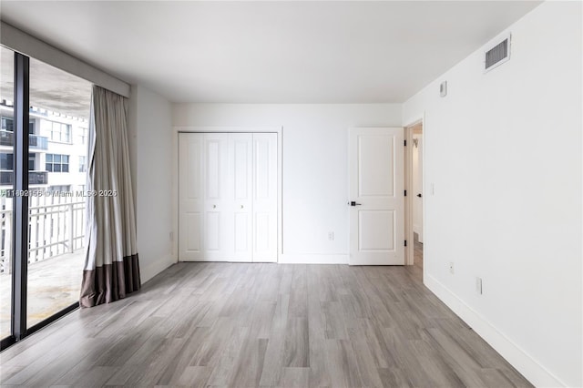 6061 Collins Ave Unit 7D, Miami Beach, FL 33140 - unfurnished bedroom with wood finished floors, baseboards, access to exterior, and a closet