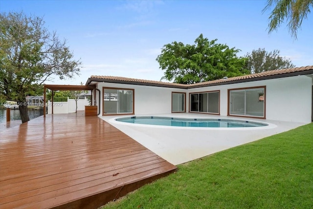 1910 NW 36th St, Oakland Park, FL 33309 - rear view of property with a deck with water view, an outdoor pool, a lawn, stucco siding, and a tiled roof
