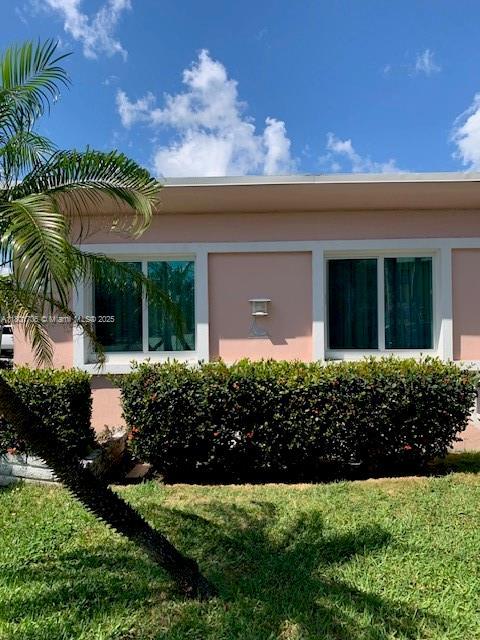 1785 Calais Dr Unit 7, Miami Beach, FL 33141 - view of side of property with stucco siding and a lawn