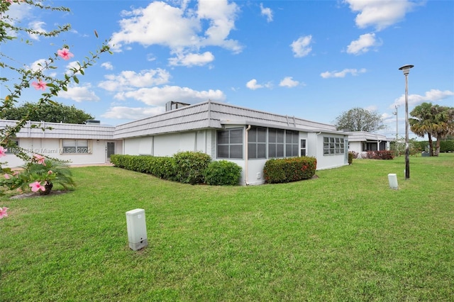 rear view of property featuring a lawn
