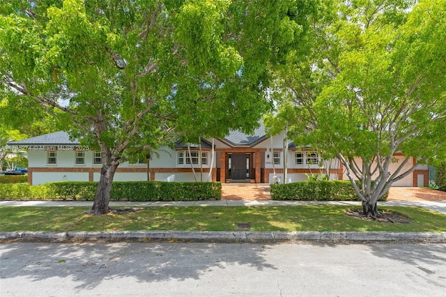 2898 SW 2nd Ave, Miami, FL 33129 - view of front of home with a front yard, a shingled roof, and driveway