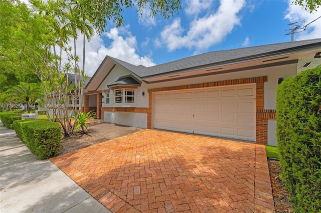 2898 SW 2nd Ave, Miami, FL 33129 - ranch-style home with decorative driveway, stucco siding, and a garage