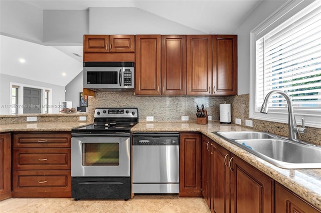 2898 SW 2nd Ave, Miami, FL 33129 - kitchen featuring appliances with stainless steel finishes, a sink, lofted ceiling, decorative backsplash, and brown cabinets
