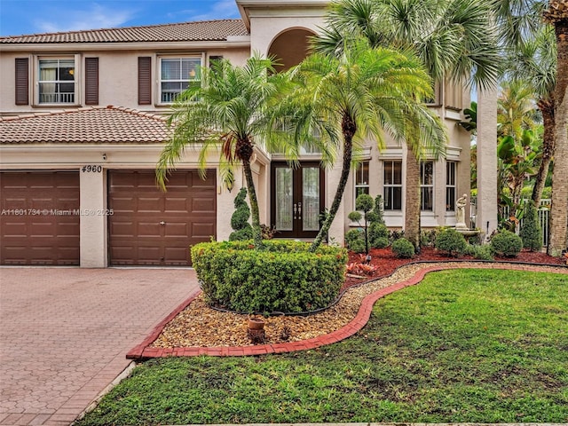4960 SW 158th Ave, Miramar, FL 33027 - view of front of property featuring french doors, a tile roof, driveway, stucco siding, and a garage