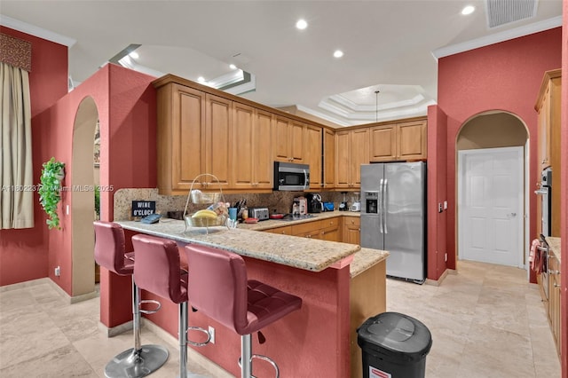 18951 SW 30th St, Miramar, FL 33029 - kitchen with stainless steel appliances, tasteful backsplash, a peninsula, ornamental molding, and a breakfast bar area