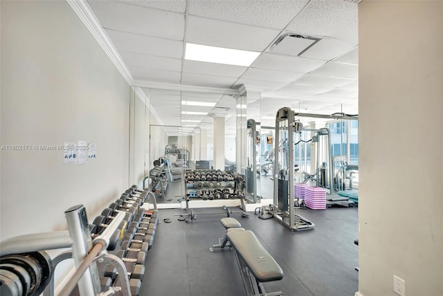 exercise room with a drop ceiling and ornamental molding