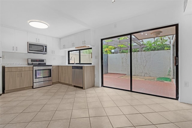 4718 SW 67th Ave Unit B6, Miami, FL 33155 - kitchen with stainless steel appliances, light countertops, white cabinets, and a sink
