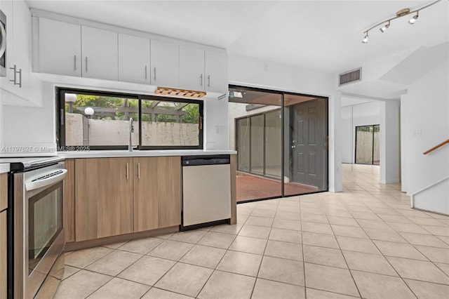 4718 SW 67th Ave Unit B6, Miami, FL 33155 - kitchen with appliances with stainless steel finishes, a sink, light countertops, white cabinets, and plenty of natural light