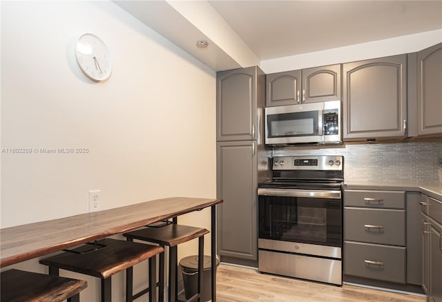 900 Saint Charles Pl Unit 621, Pembroke Pines, FL 33026 - kitchen featuring stainless steel appliances, gray cabinetry, light wood-style flooring, and tasteful backsplash