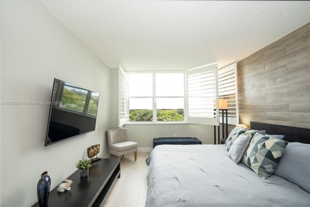 900 Saint Charles Pl Unit 621, Pembroke Pines, FL 33026 - bedroom featuring multiple windows, an accent wall, wooden walls, and a textured ceiling