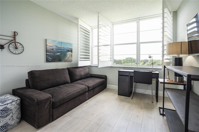 900 Saint Charles Pl Unit 621, Pembroke Pines, FL 33026 - living room featuring a desk, light wood finished floors, baseboards, and a textured ceiling