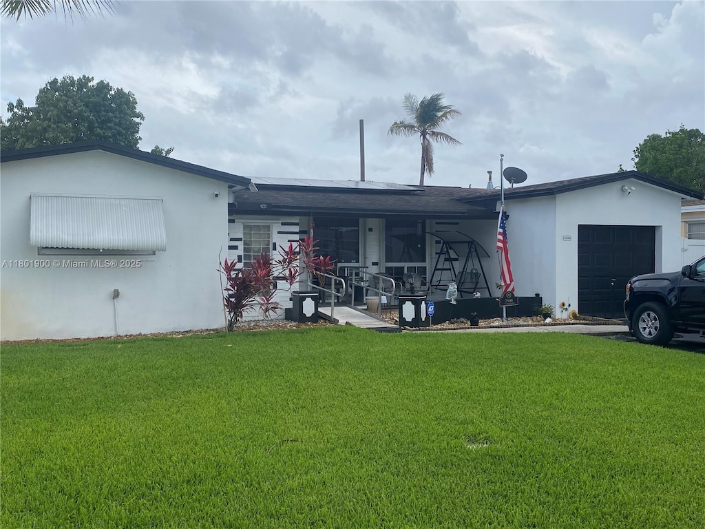view of front of home featuring covered porch, a front lawn, stucco siding, and a garage