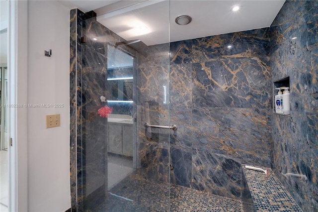 bathroom featuring a marble finish shower
