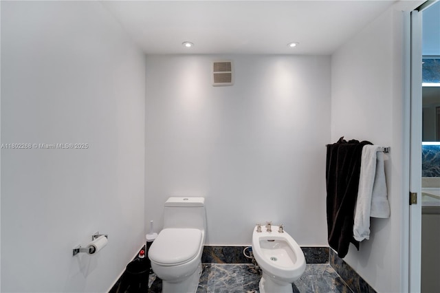 bathroom featuring a bidet, toilet, baseboards, and recessed lighting