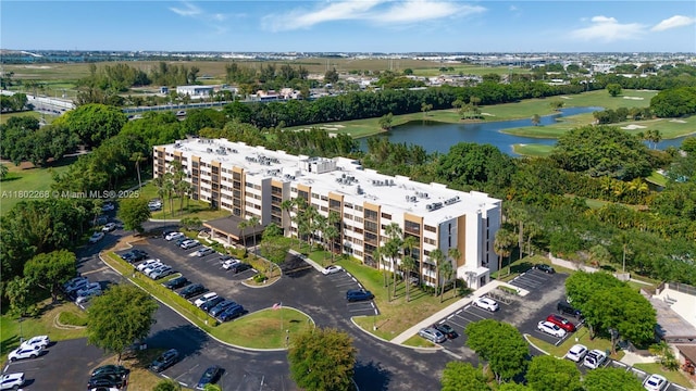 aerial view of a nearby body of water, apartment complex / building, and a golf course