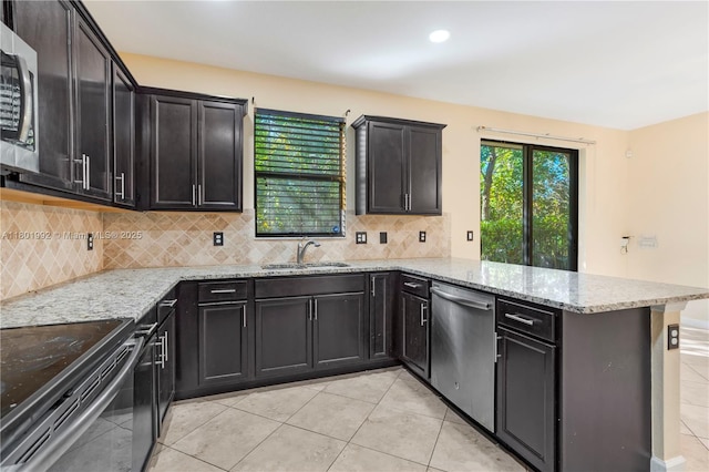 6973 Broadland Way, Coconut Creek, FL 33073 - kitchen with appliances with stainless steel finishes, a sink, a peninsula, backsplash, and light tile patterned flooring