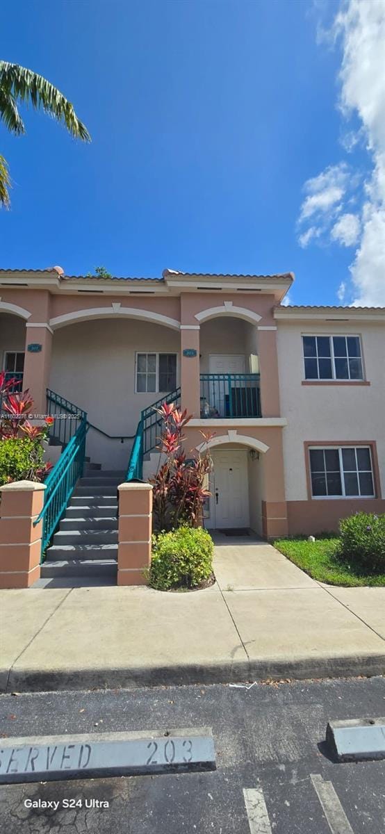 1241 SE 29th St Unit 203-27, Homestead, FL 33035 - view of front facade with stucco siding, a balcony, and stairs