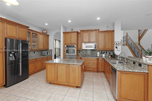 4968 SW 183rd Ave, Miramar, FL 33029 - kitchen featuring black appliances, a sink, backsplash, a peninsula, and a kitchen island