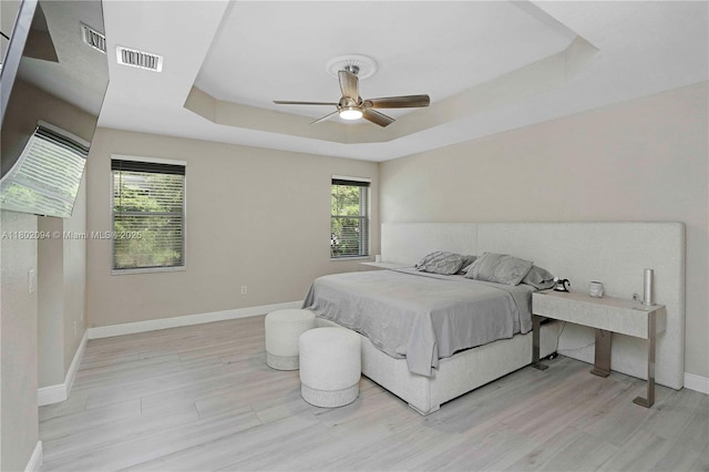 4968 SW 183rd Ave, Miramar, FL 33029 - bedroom featuring a raised ceiling, multiple windows, baseboards, and light wood-style floors