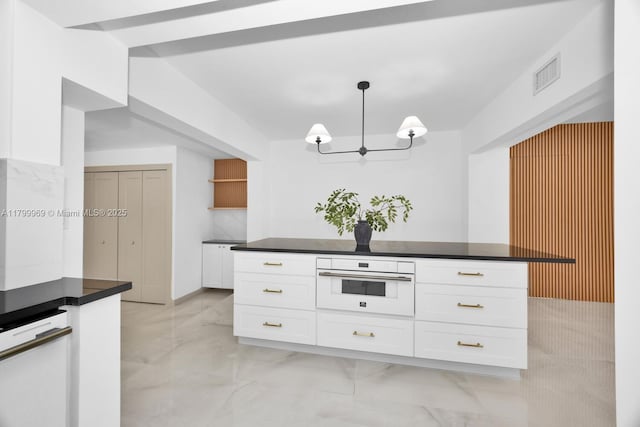 5410 SW 2nd St, Miami, FL 33134 - kitchen featuring oven, light marble finish flooring, a chandelier, white cabinetry, and dark countertops