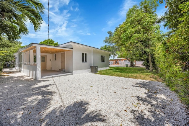 5410 SW 2nd St, Miami, FL 33134 - back of house with stucco siding, driveway, a lawn, and a carport