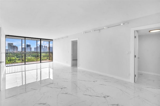 20335 W Country Club Dr Unit 1108, Aventura, FL 33180 - spare room featuring marble tiled flooring, a skyline view, expansive windows, and baseboards