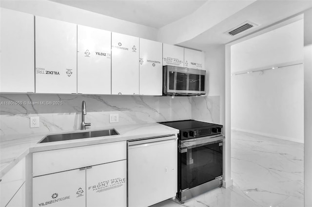 20335 W Country Club Dr Unit 1108, Aventura, FL 33180 - kitchen with stainless steel appliances, a sink, white cabinetry, decorative backsplash, and light marble finish flooring