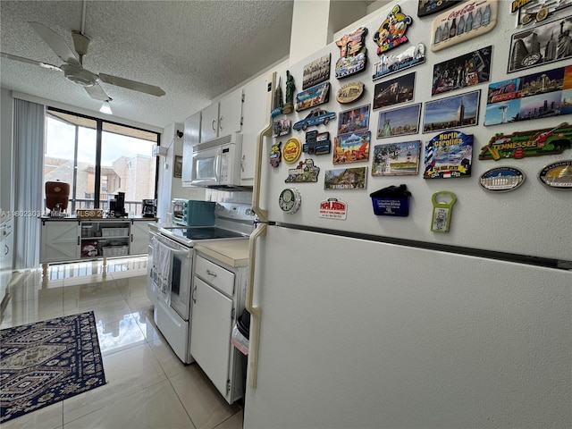 3550 Blue Lake Dr Unit 501, Pompano Beach, FL 33064 - kitchen with white appliances, a ceiling fan, white cabinets, a textured ceiling, and light tile patterned floors