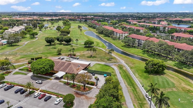 view of property location featuring a golf course and a nearby body of water