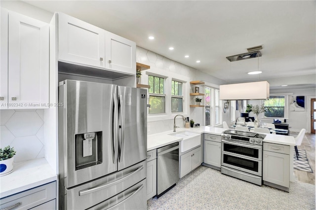 38 NW 47th Ter, Miami, FL 33127 - kitchen with appliances with stainless steel finishes, gray cabinetry, a sink, open shelves, and a peninsula