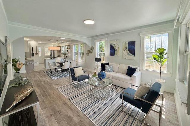 38 NW 47th Ter, Miami, FL 33127 - living room featuring arched walkways, plenty of natural light, light wood finished floors, and crown molding