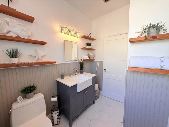 38 NW 47th Ter, Miami, FL 33127 - half bathroom with toilet, tile patterned flooring, wainscoting, and vanity